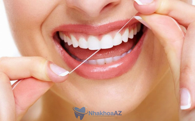 Dùng chỉ nha khoa để lấy thức ăn mắc vào kẽ răng